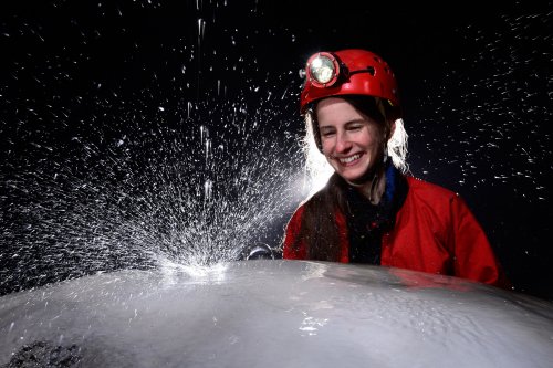 Dimnice Jama (Slovénie) - Jeune femme regardant exploser une goutte tombant sur un dôme blanc de calcite(SP-17-0506)